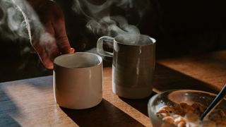 Cups of steaming coffee sitting on a table