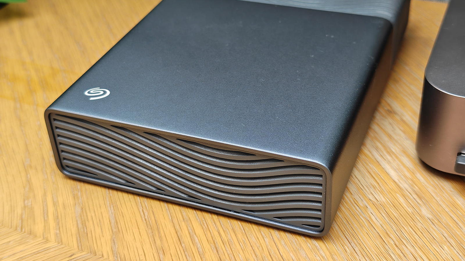 Photos of a silver grey HD box on a wooden desk