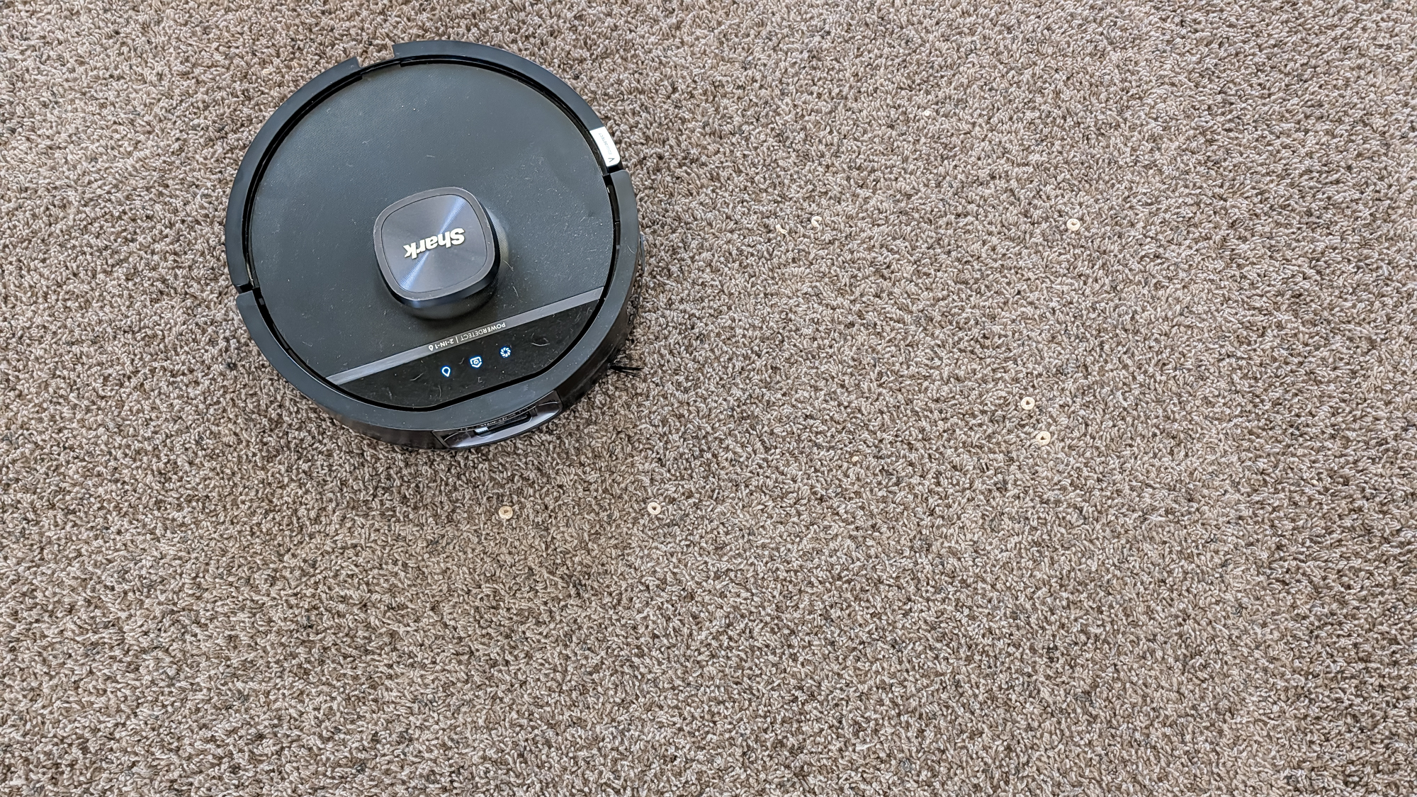Shark UV Reveal PowerDetect Robot Vacuum on a carpet with Cheerios