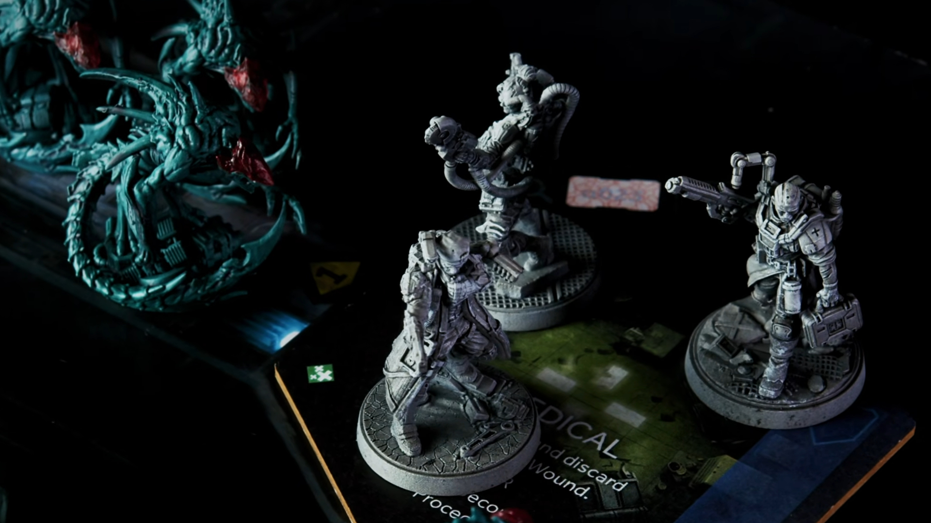 Miniatures from Nemesis Legacy face each other in a dark environment