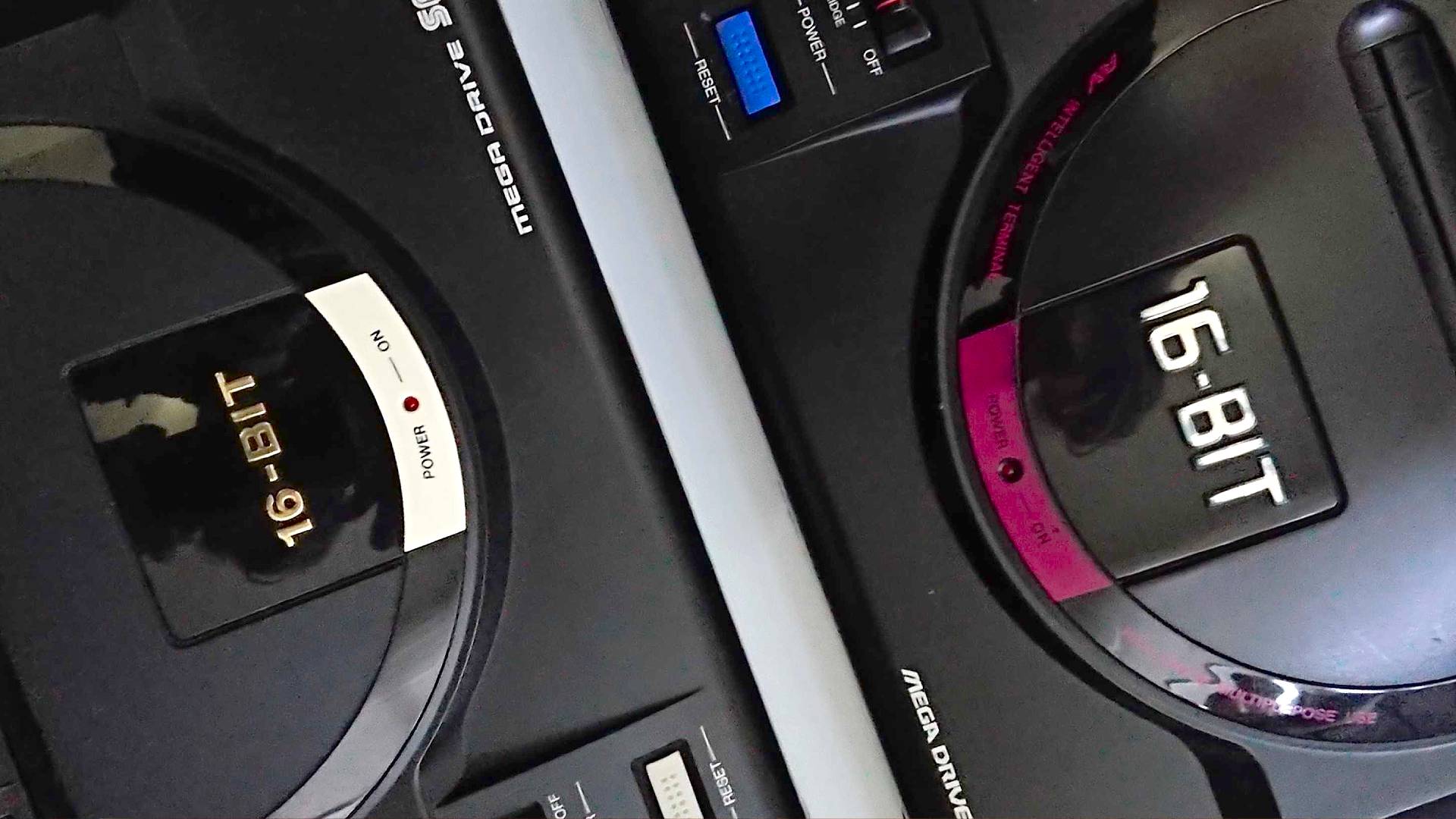 Angled photo of Japanese and UK Sega Mega Drive consoles facing eachother.