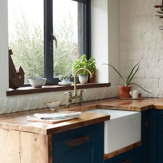 kitchen with wooden worktop and blue drawers