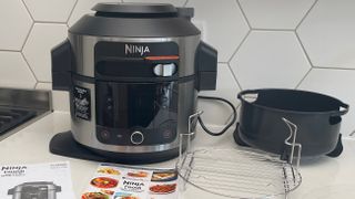 The Ninja Foodi 11-in-1 SmartLid multi-cooker with all its accessories on a kitchen countertop