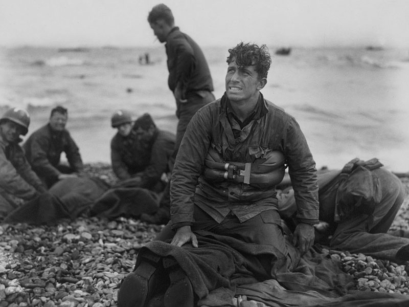 US Army soldiers recovering remains of comrades at Omaha Beach, Normandy, France, 6 Jun 1944.