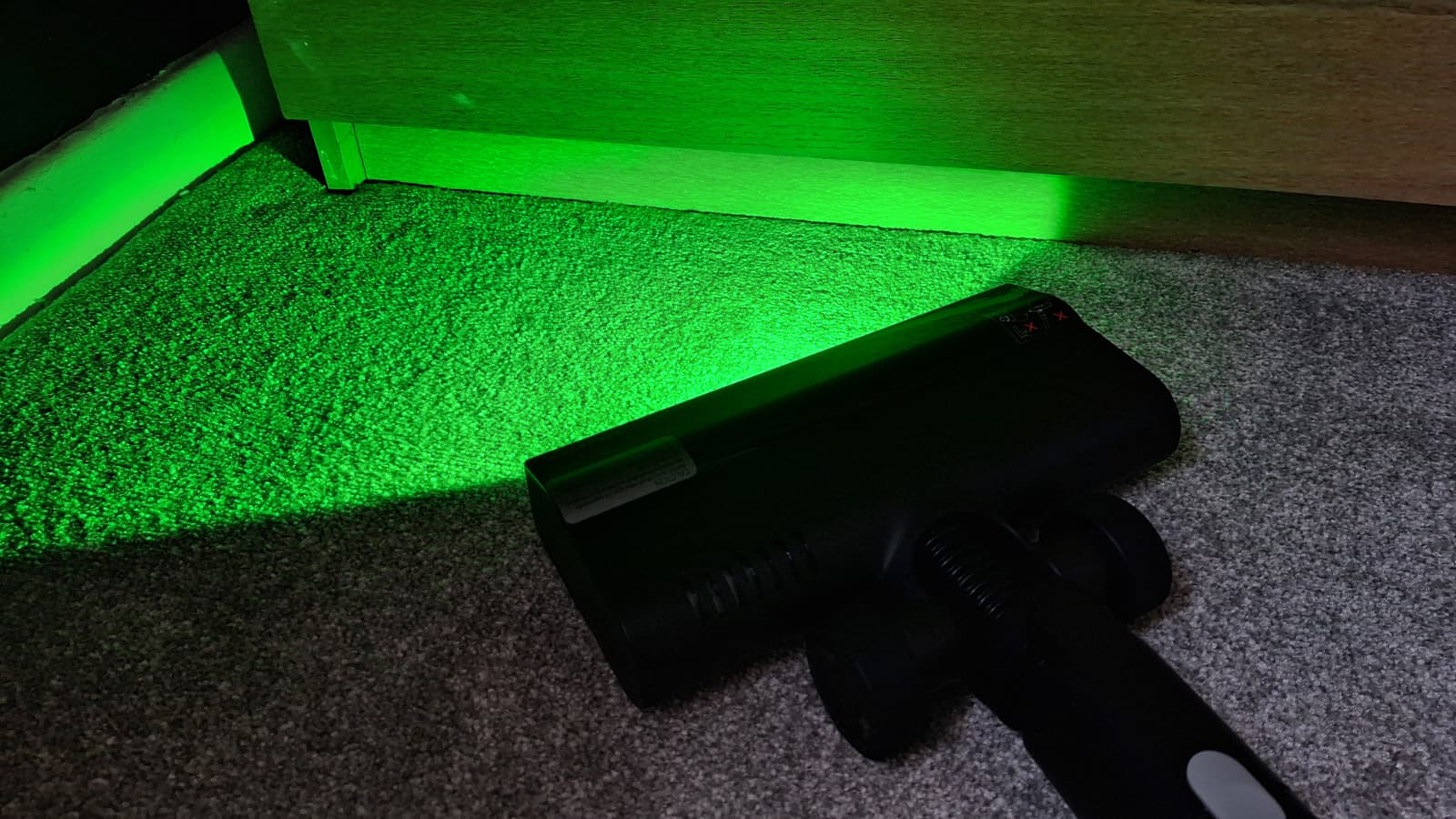 Roborock H60 Hub Ultra with green light illuminating a corner
