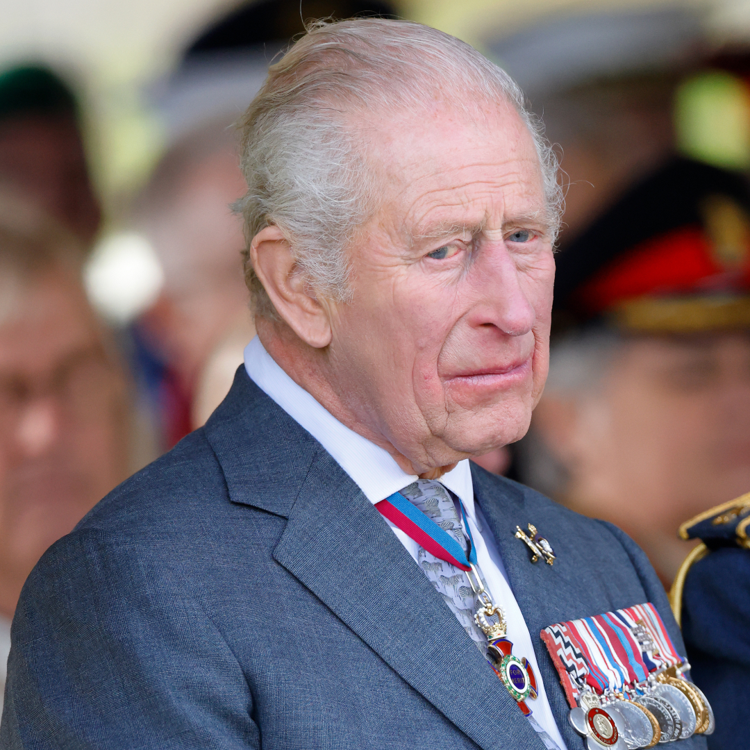 King Charles wears a blue suit with military medals attached and he looks very sad