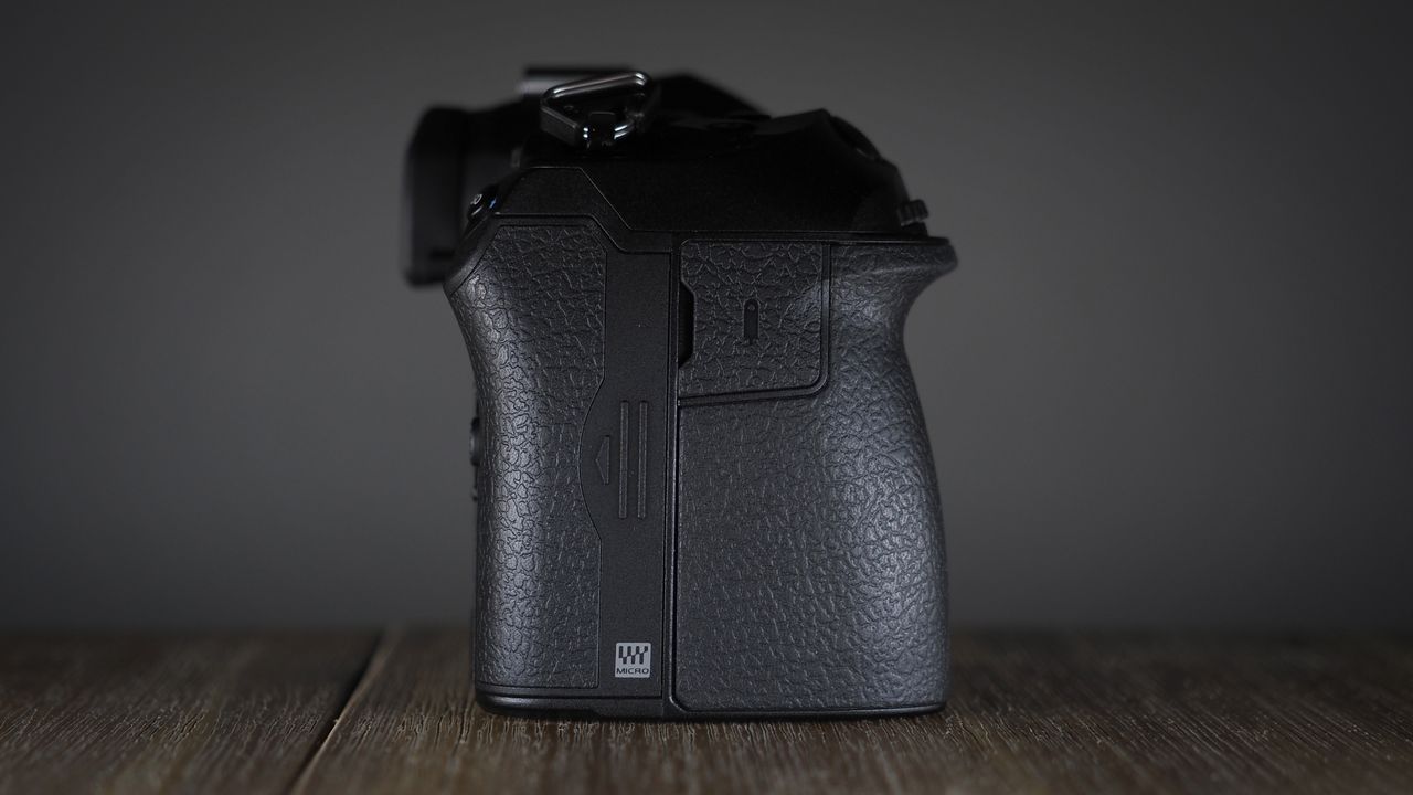 OM System OM-1 Mark II on a wooden surface, against a dark background