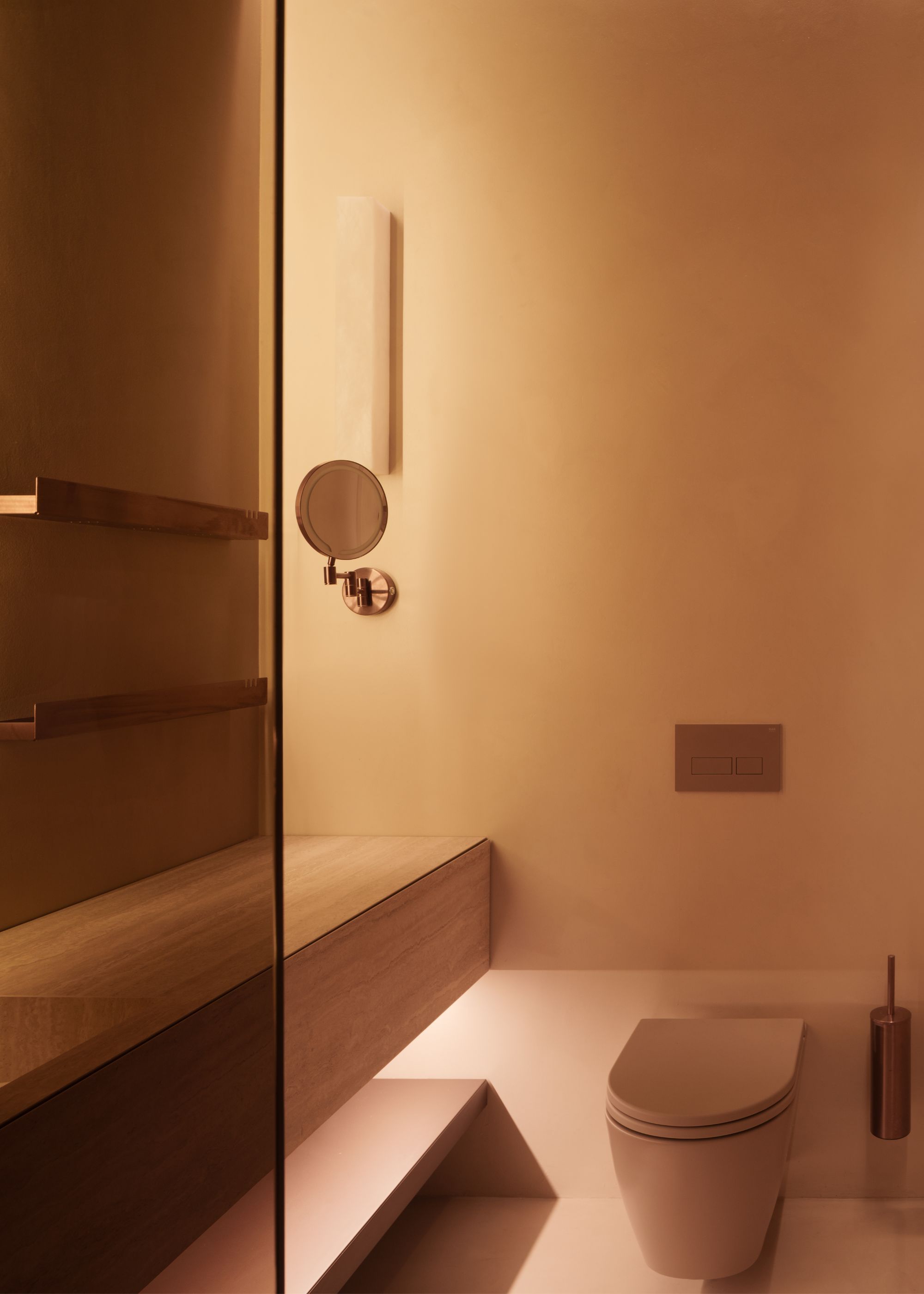 A warm modern bathroom in sunset tones with a closed dusty pink toilet