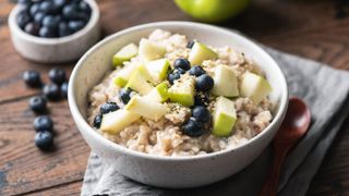 Bowl of porridge with apples and blueberries