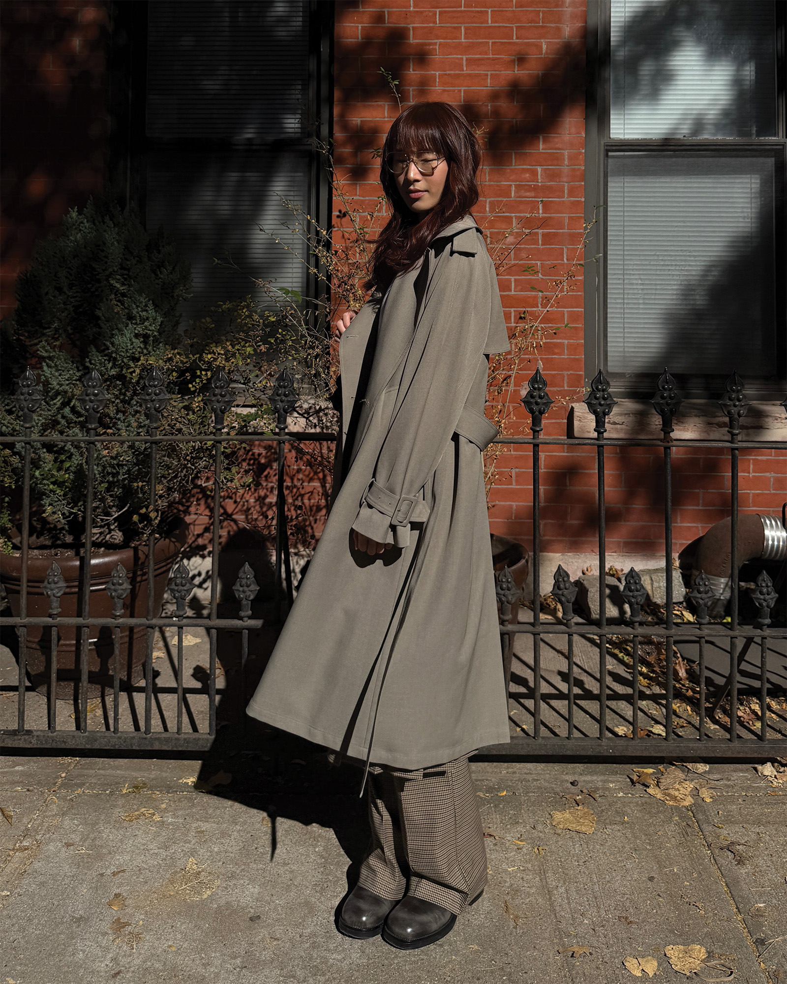 Who What Wear Editor in Residence Kristina Ang wearing a taupe trench coat with matching trousers.