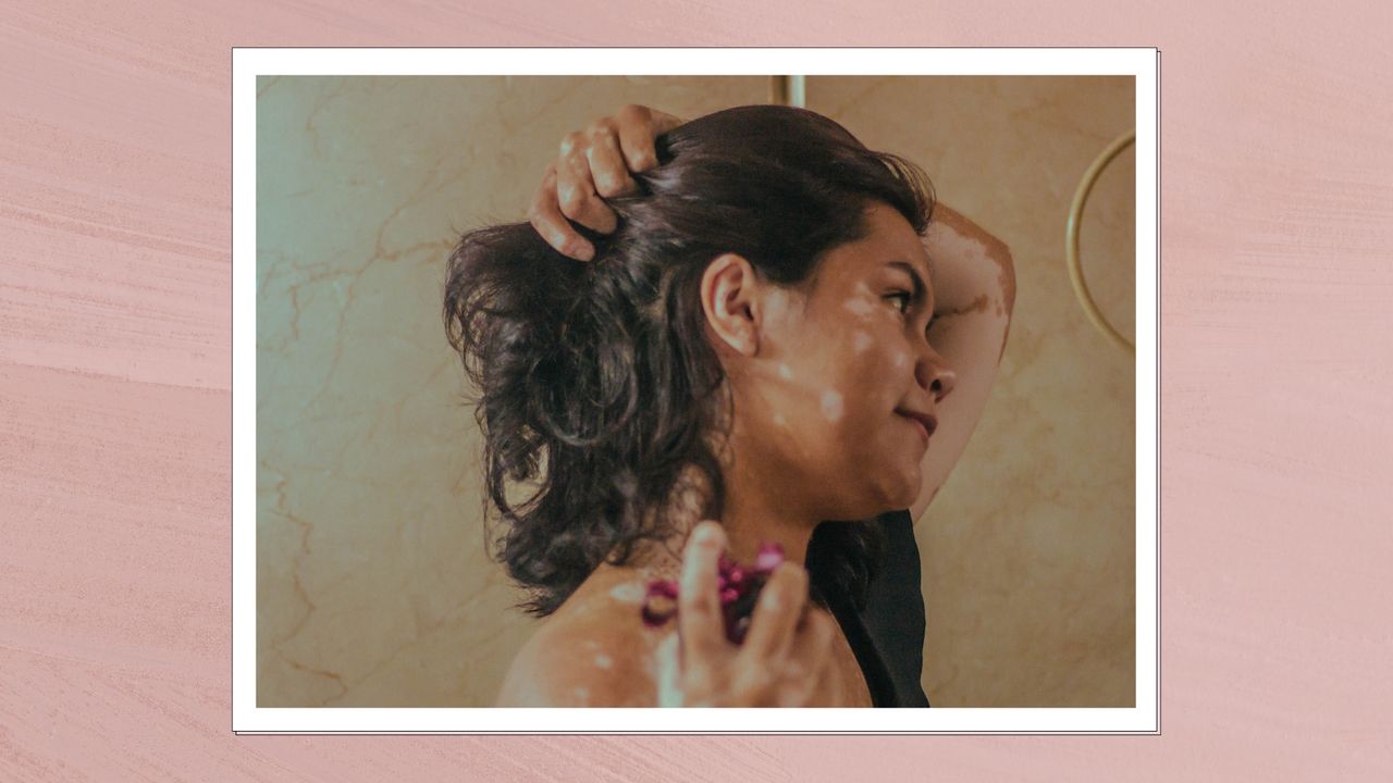 A close up of a woman lifting up her hair and spraying perfume on her neck/in a dark pink, textured template