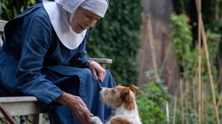 Judy Parfitt as Sister Monica Joan, sitting on a bench and shaking the paw of Nothing the dog