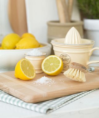Cut lemons and lemon squeezer on chopping board