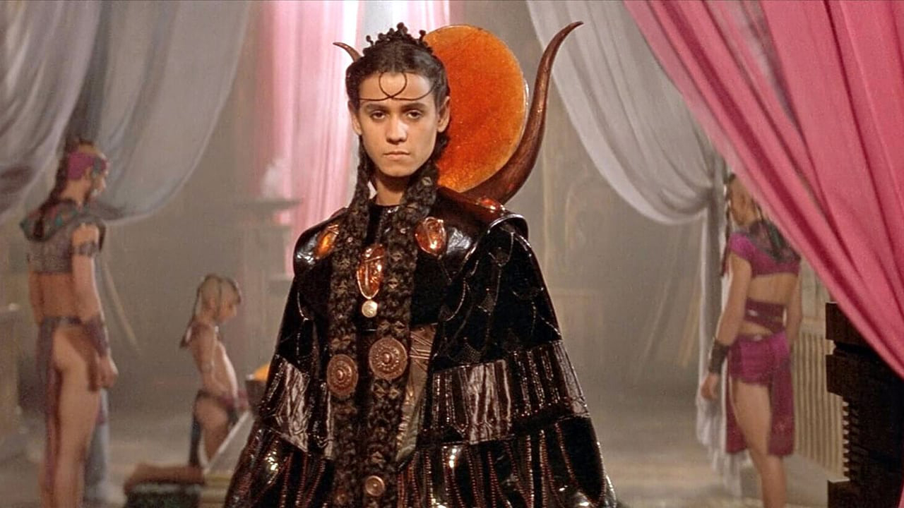 A young man in elegant dress surrounded by servants in the movie Stargate (1994)