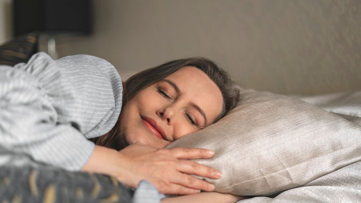 A woman sleeping on her side smiling