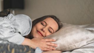 A woman sleeping on her side smiling