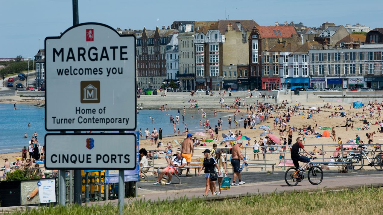 People and families on the beach sunbathing, swimming, playing and generally enjoying the fine sunshine in Margate