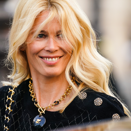 Claudia Schiffer wearing a black jacket smiling, with the wind in her blonde hair demonstrating hair colours for the over 50s