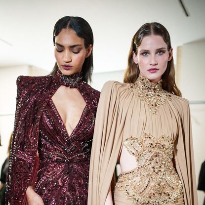 Two models posing for the camera backstage at a show