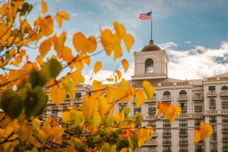 Orange leaves in front of the 24-story Grand America Hotel in Utah during a fall day