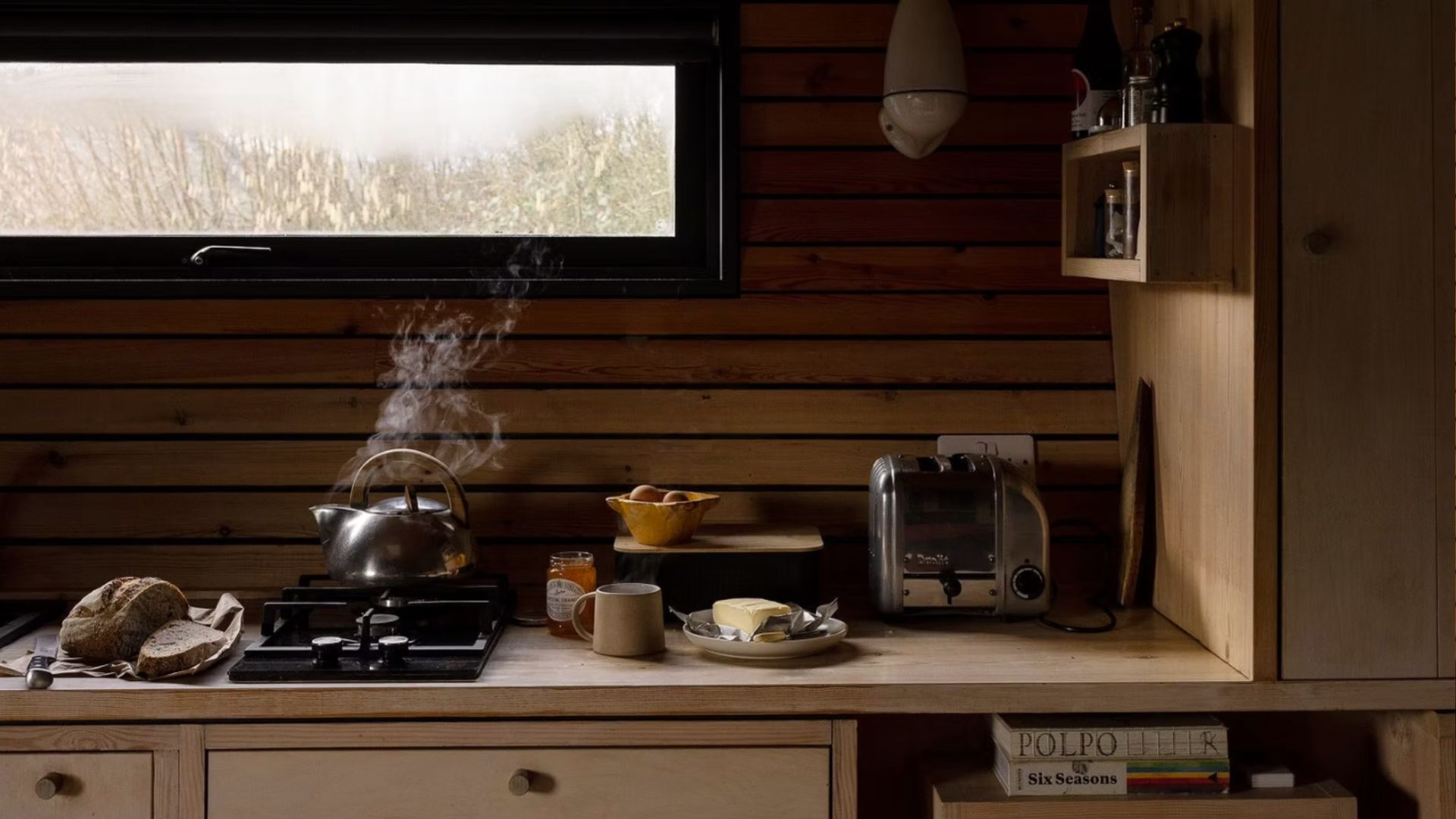 The side cabinet in the Hergest Lee Cabin with a boiling kettle and breakfast on the side