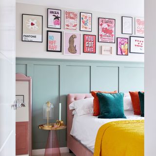 Colourful bedroom with light blue panelled wall, hanging artwork