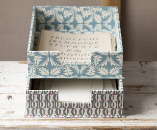 A set of two paper patterned letter trays stacked on top of one another