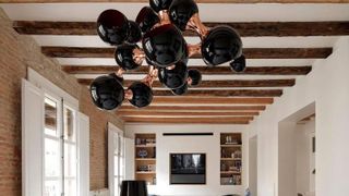 black contemporary ceiling light with timber beams on ceiling