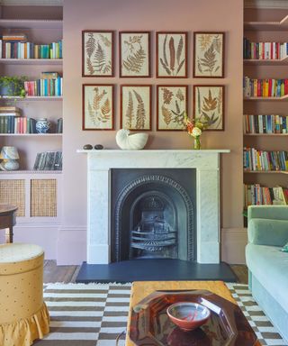 Pink bedroom with gallery wall, fireplace, alcove shelving