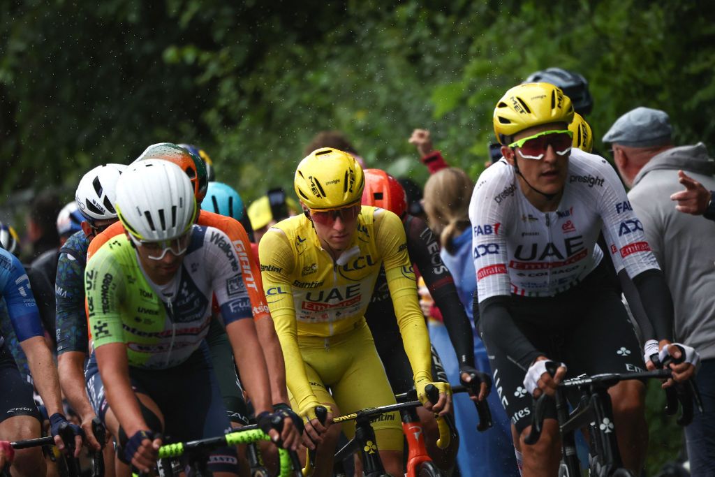 UAE Team Emirates team's Slovenian rider Tadej Pogacar wearing the overall leader's yellow jersey (C) cycles with the pack of riders (peloton) during the 8th stage of the 111th edition of the Tour de France cycling race, 183,5 km between Semur-en-Auxois and Colombey-les-deux-Eglises, on July 6, 2024. (Photo by Anne-Christine POUJOULAT / AFP)