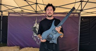 Plini poses with his modded Strandberg Boden signature model in a tent, hours before playing Bristol's ArcTanGent Festival 2024.