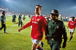 Eric Cantona is escorted off the pitch by a Turkish policeman after being shown a red card against Galatasaray in November 1993.