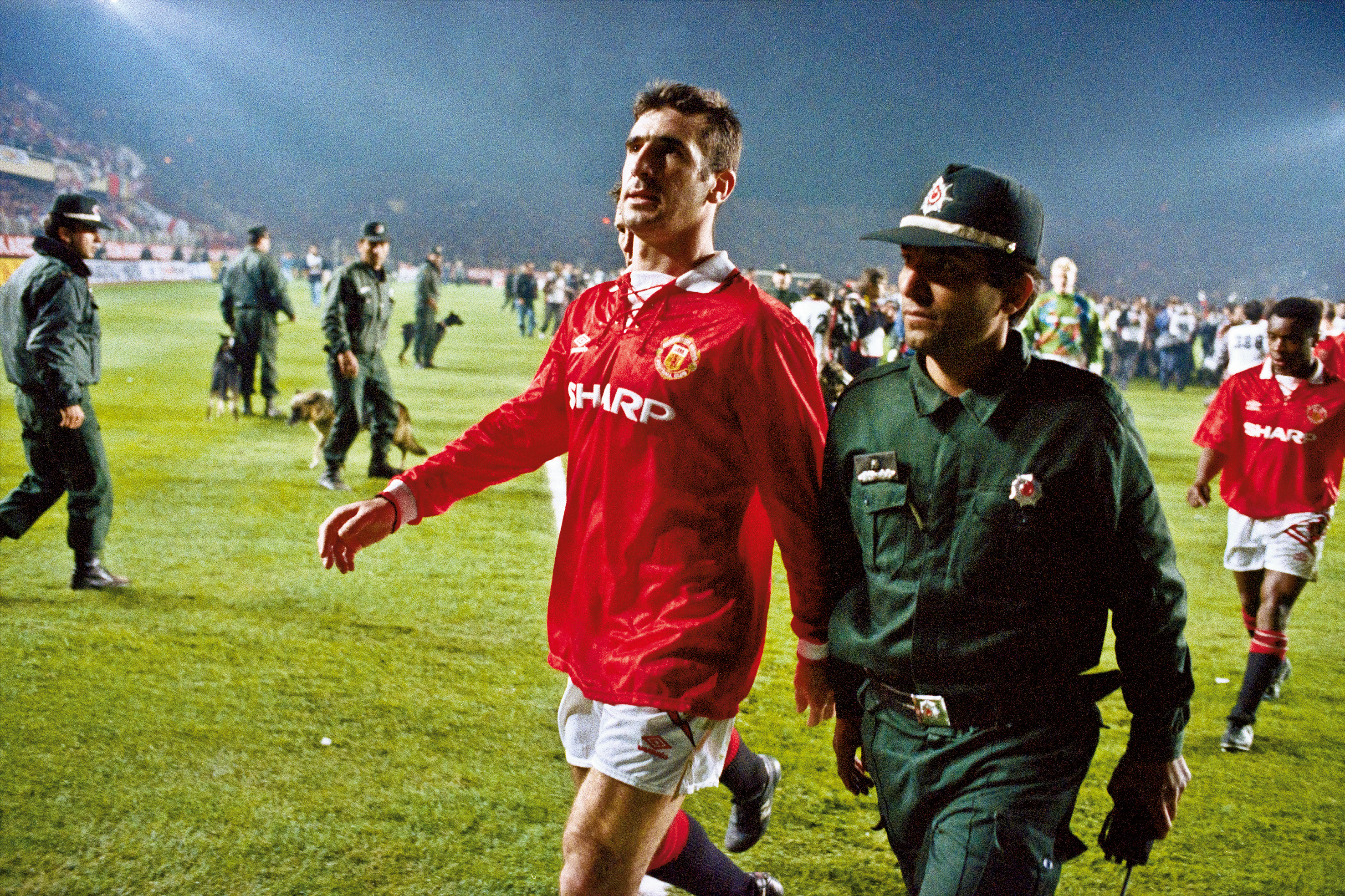 Eric Cantona is escorted off the pitch by a Turkish policeman after being shown a red card against Galatasaray in November 1993.