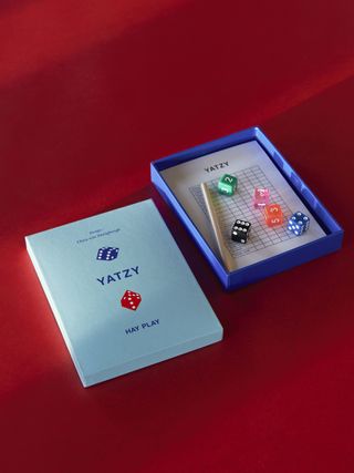 A Yatzy table game set on a red surface.