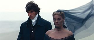 Jacob Elordi and Margot Robbie looking down at funeral in Wuthering Heights