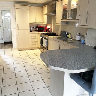 Before view of kitchen with wooden kitchen cupboards and red microwave grill