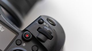 A close-up of the M-Fn button on a Canon EOS R5