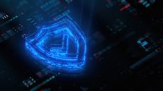 A digital render of a hologram of a shield bearing a tick symbol representing firewall as a service (FWaaS). Decorative: the hologram is hovering above a lightly-blurred dark touchscreen bearing glowing red, green, and blue lights.