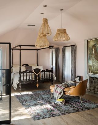 bedroom with black four poster, large area rug and seating