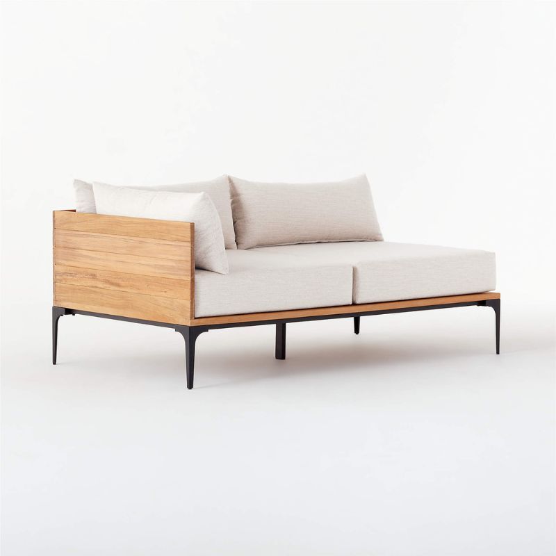 An off white CB2 left arm loveseat with teak wood, for the best outdoor furniture brands.