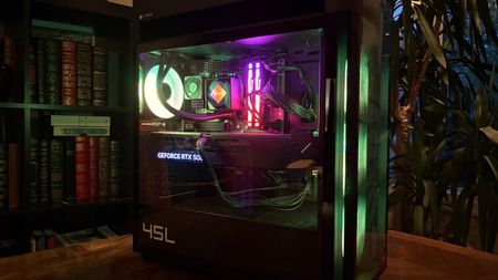 A modern HP Omen Max 45L computer tower with a glass side panel showcasing colorful internal components, including a glowing cooling fan and RAM, is set against a backdrop of bookshelves.