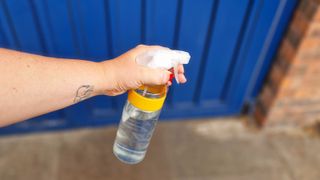 Spraying vinegar outside a front door 