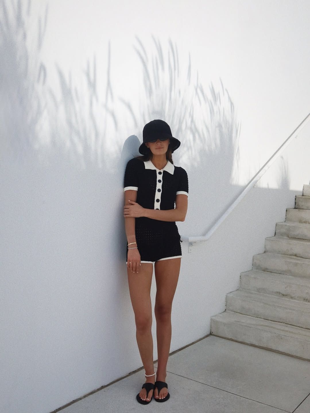 Woman wearing a statement hat with a knit shorts set.