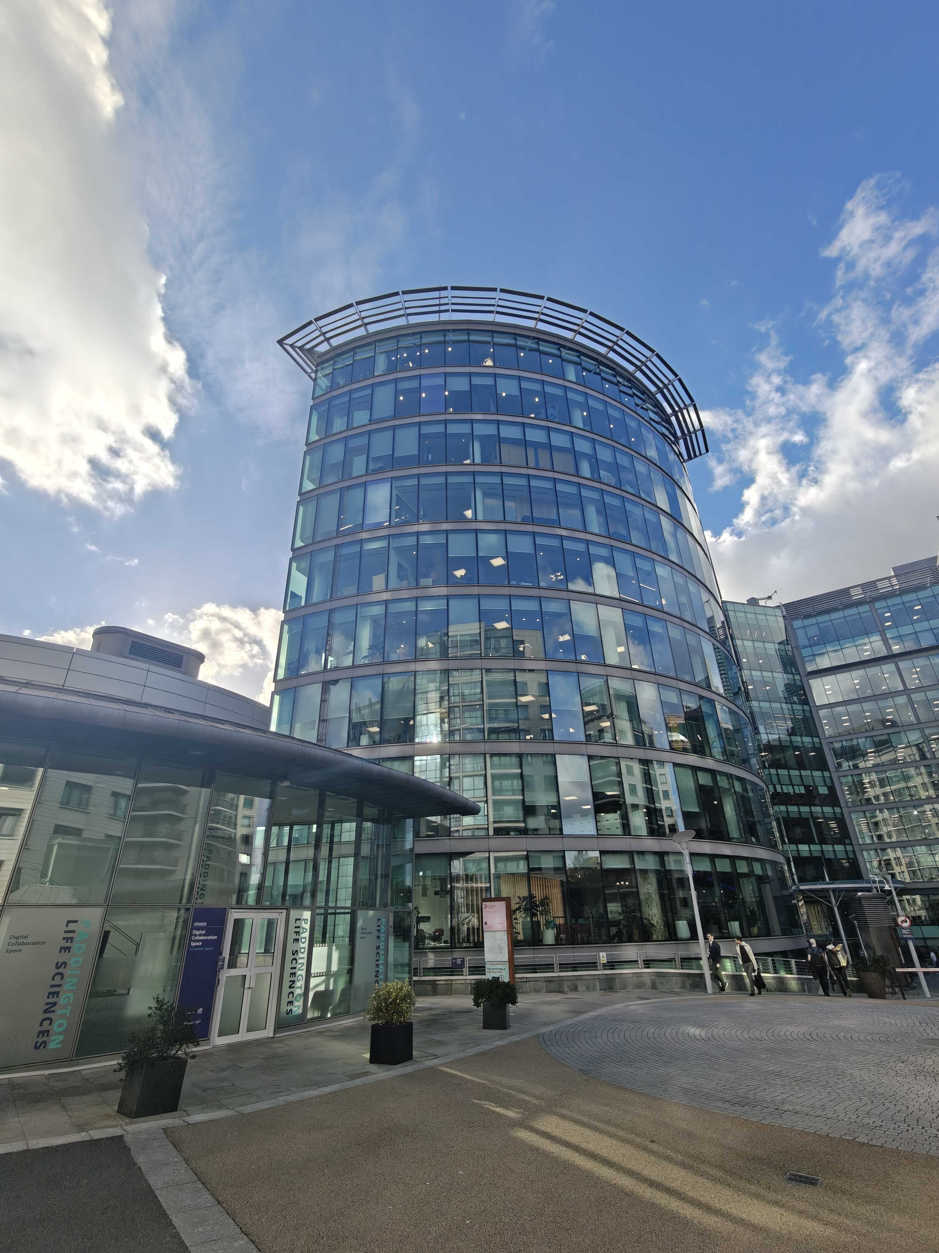 A picture of a glass office building during the day