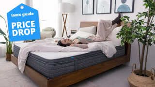 woman laying on Origin Hybrid mattress with headphones on and tom's guide deal badge in top corner