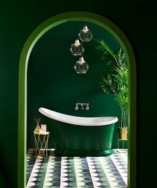 bathroom with a green roll-top slipper-style bath with green painted walls and green, black and white patterned floor tiles