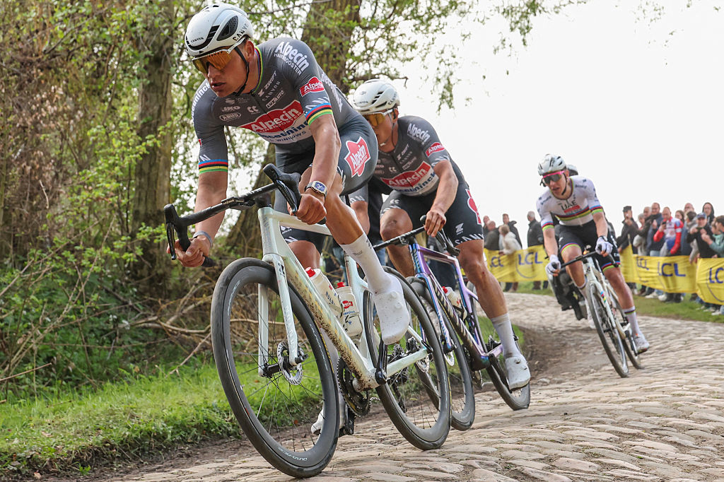 Alpecin-Deceuninck's Dutch rider Mathieu van der Poel (L), Alpecin-Deceuninck's Belgian rider Jasper Philipsen and UAE Team Emirate's Slovenian rider Tadej Pogacar (R) cycle in a breakaway on a cobblestone road during the 122nd edition of the Paris-Roubaix one-day classic cycling race, 259,2 km between Compiegne and Roubaix, northern France on April 13, 2025. (Photo by Francois LO PRESTI / AFP)