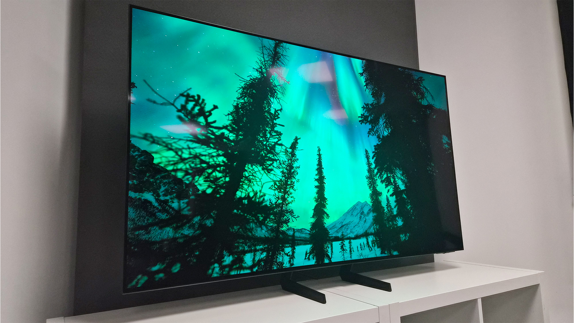 Samsung S85H OLED TV on screen are trees and aurora borealis