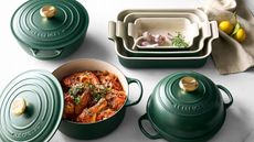 The Le Creuset enameled cast iron collection in deep Foret green, on a marble counter. 