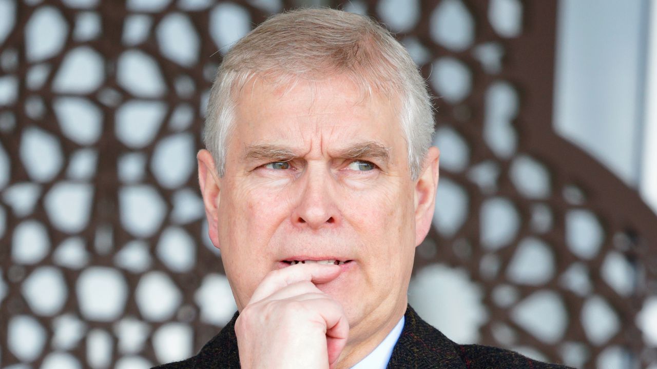 Prince Andrew wearing a black coat and looking anxious 